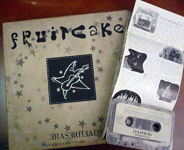  Fruitcake Collector’s Edition Book & Cassette – Alt TextA photo showing both the “Fruitcake” red cassette and the rare collector’s edition book side by side. The book features a colorful, storybook-style cover with whimsical illustrations. Together, they represent the Eraserheads’ unconventional 1996 Christmas project—part album, part narrative experience.