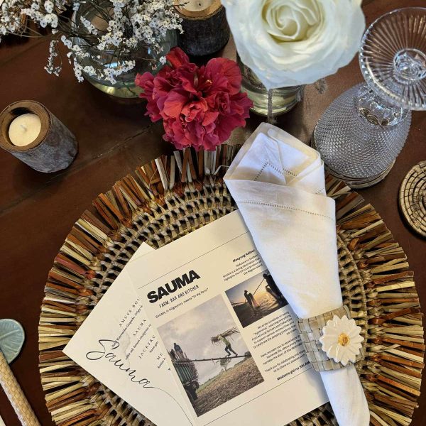 A beautifully set dining table at Sauma Farm, featuring a mix of found objects, handcrafted details, and freshly picked flowers from the garden.