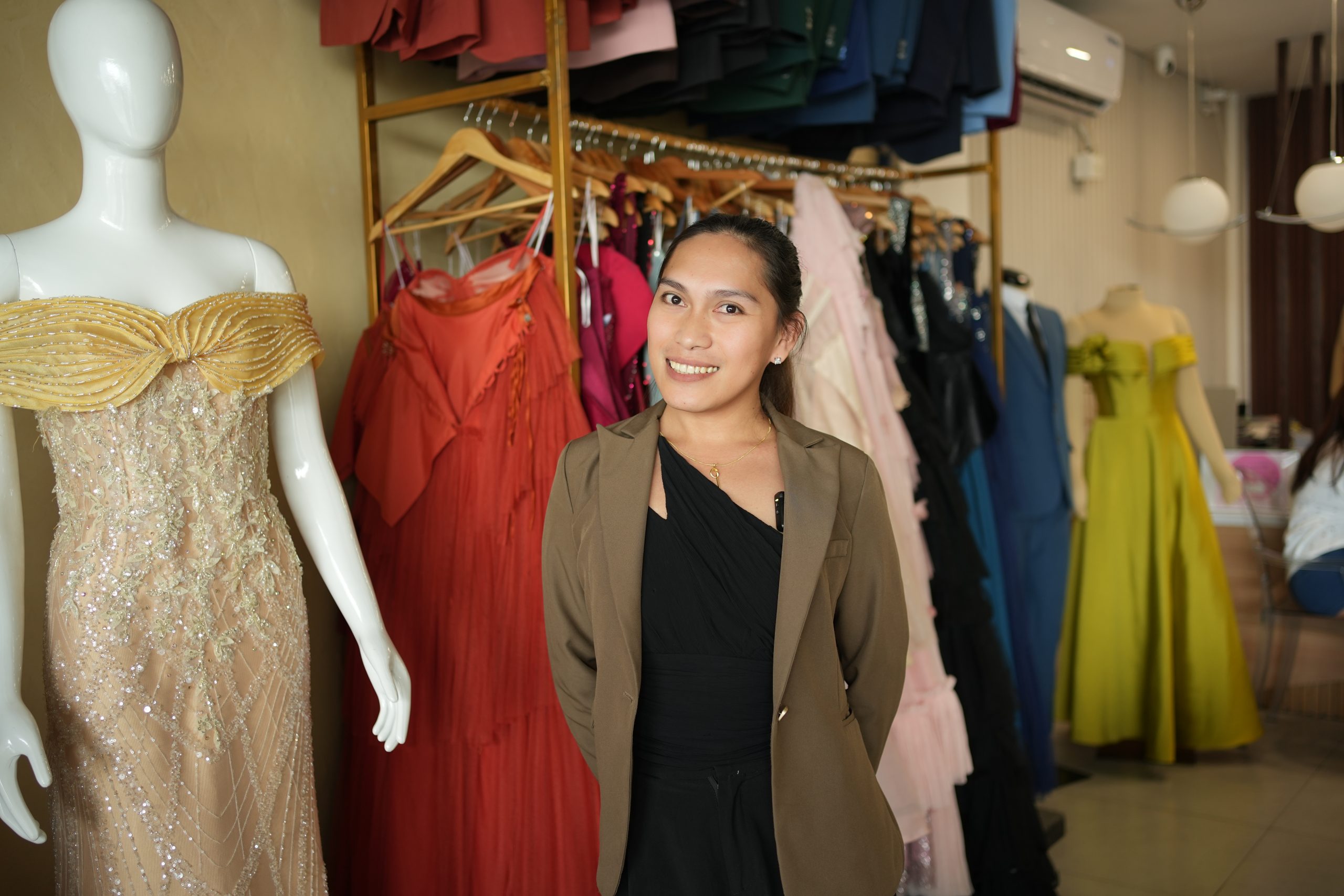 Labelle of Gown Concept Sales and Rental poses in front of her gown collection in Quezon City bridal showroom – couture on a budget