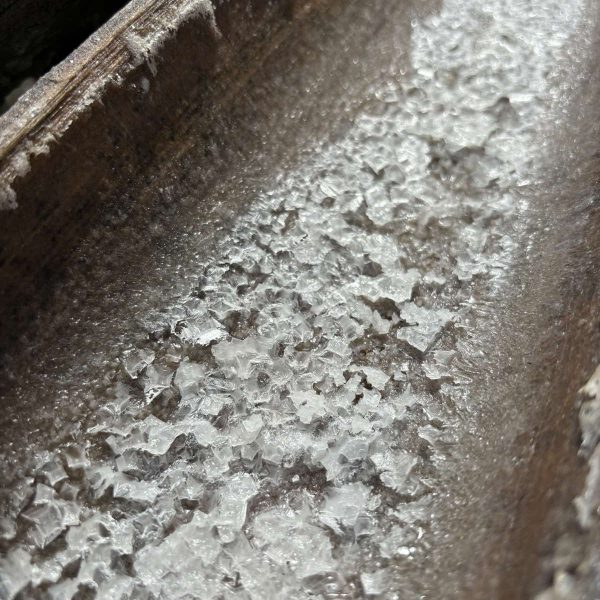 Flaky salt crystals, sun-baked and shimmering, break apart gently under the fingertips. Each one carries the taste of sea, sand, and slow work.