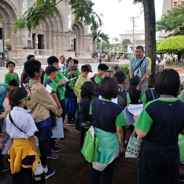 Ivan Man Dy shares cultural insights with a group of students during a walking tour, opening their eyes to the hidden histories of Manila.