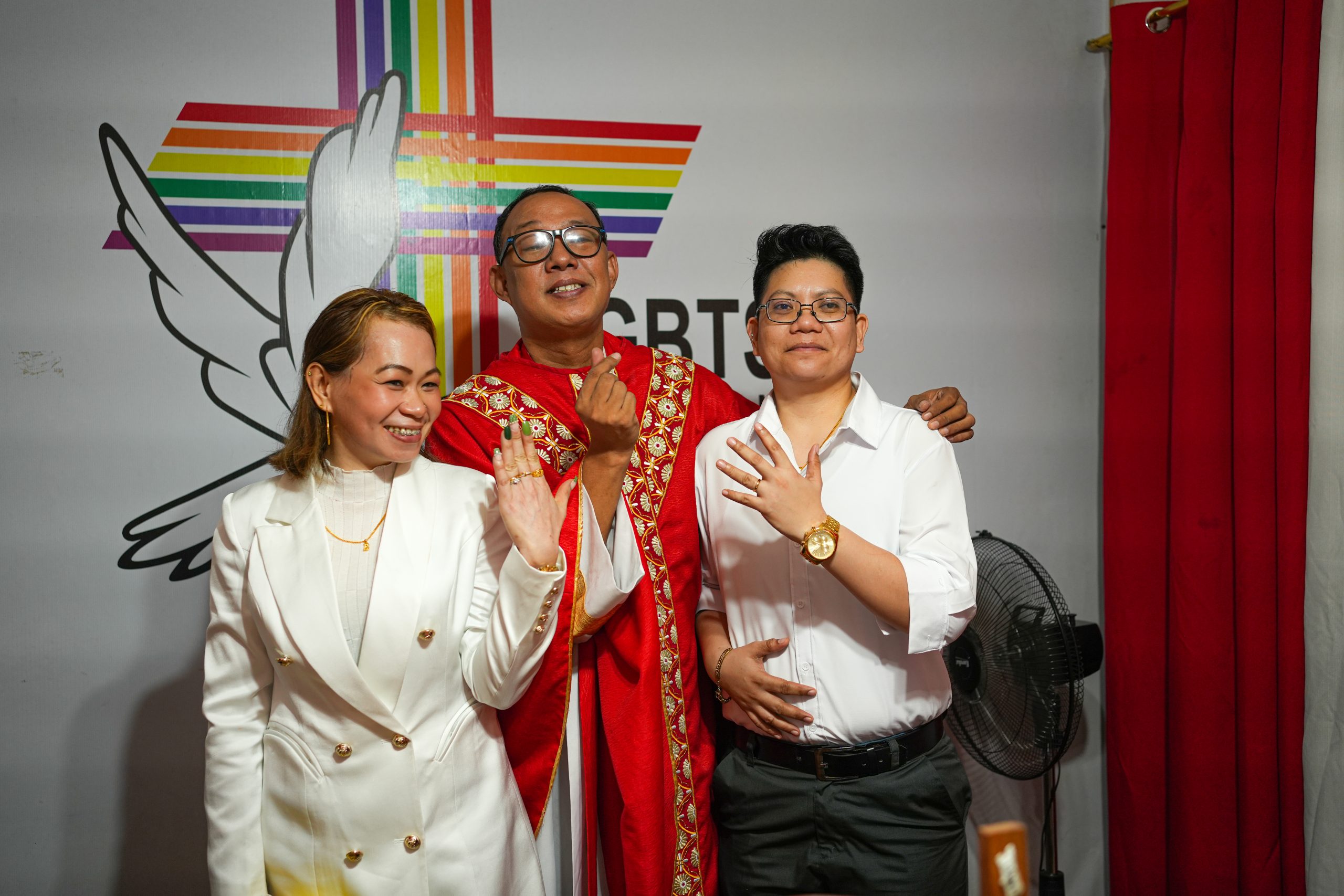 Same sex marriage Philippines couple Jacky and Bjay showing rings beside Rev. CJ Agbayani at LGBTS Christian Church, celebrating queer love and chosen commitment despite lack of legal recognition.
