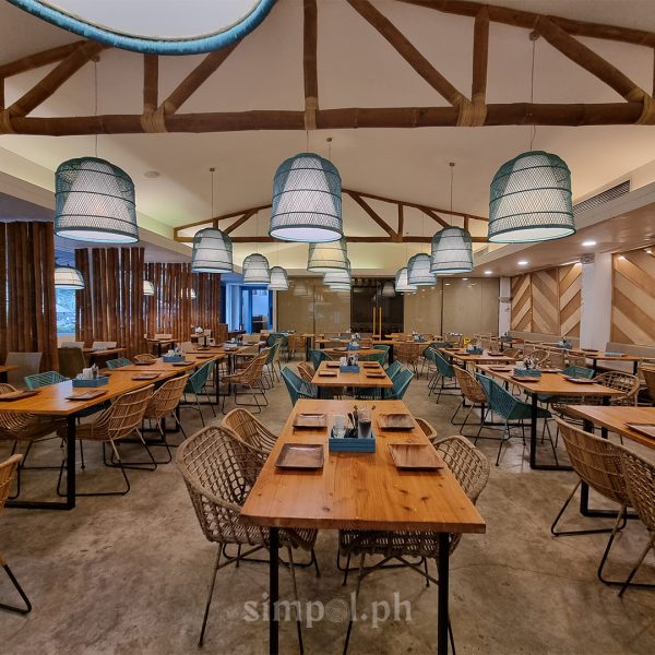 Interior of House of Lechon Cebu showing rustic Filipino design with woven textures, wooden furniture, and a welcoming dining atmosphere.