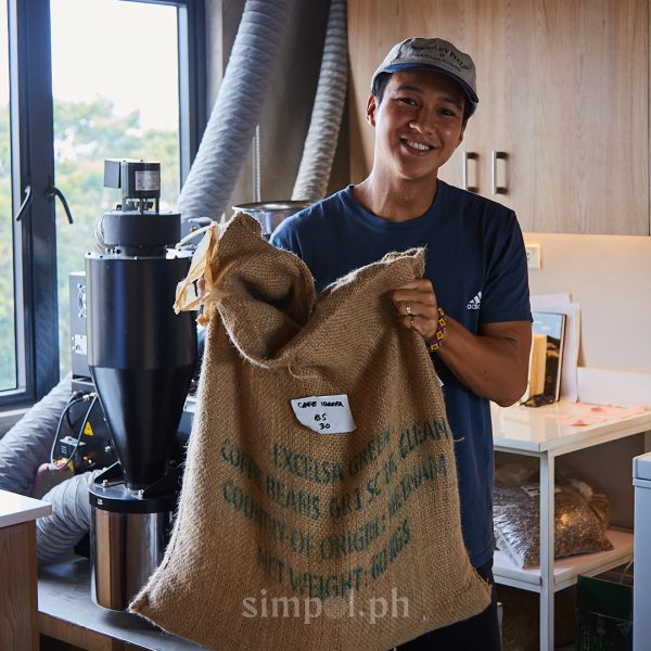 Philippine coffee content creator Timdrinkscoffee holding a sack of locally sourced coffee beans, reflecting his passion for storytelling and honoring Filipino farmers.