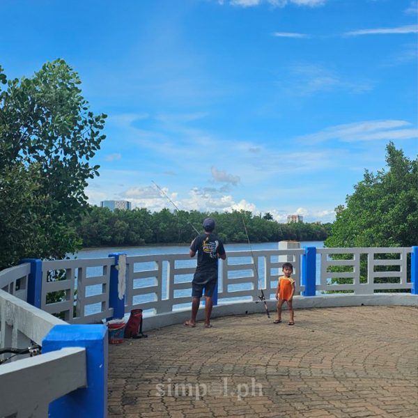 Father and son fishing by the Iloilo River Esplanade in UNESCO Creative City Iloilo, capturing everyday life and urban serenity.
